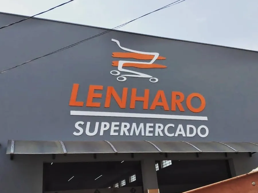 Fachada do Supermercado Lenharo com letras caixa laranja e brancas sobre ACM cinza