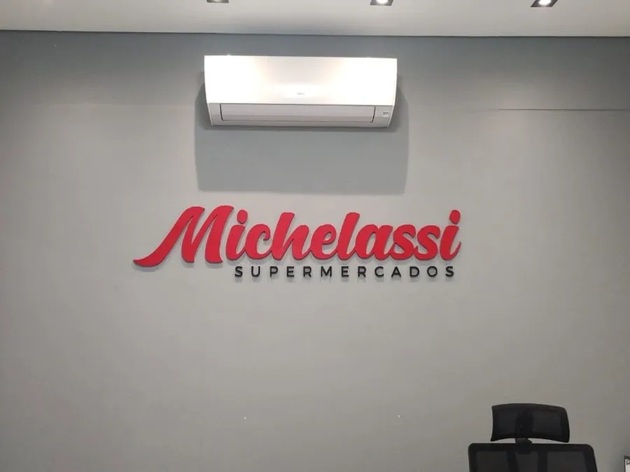 Logo vermelho do Michelassi Supermercados aplicado na parede
